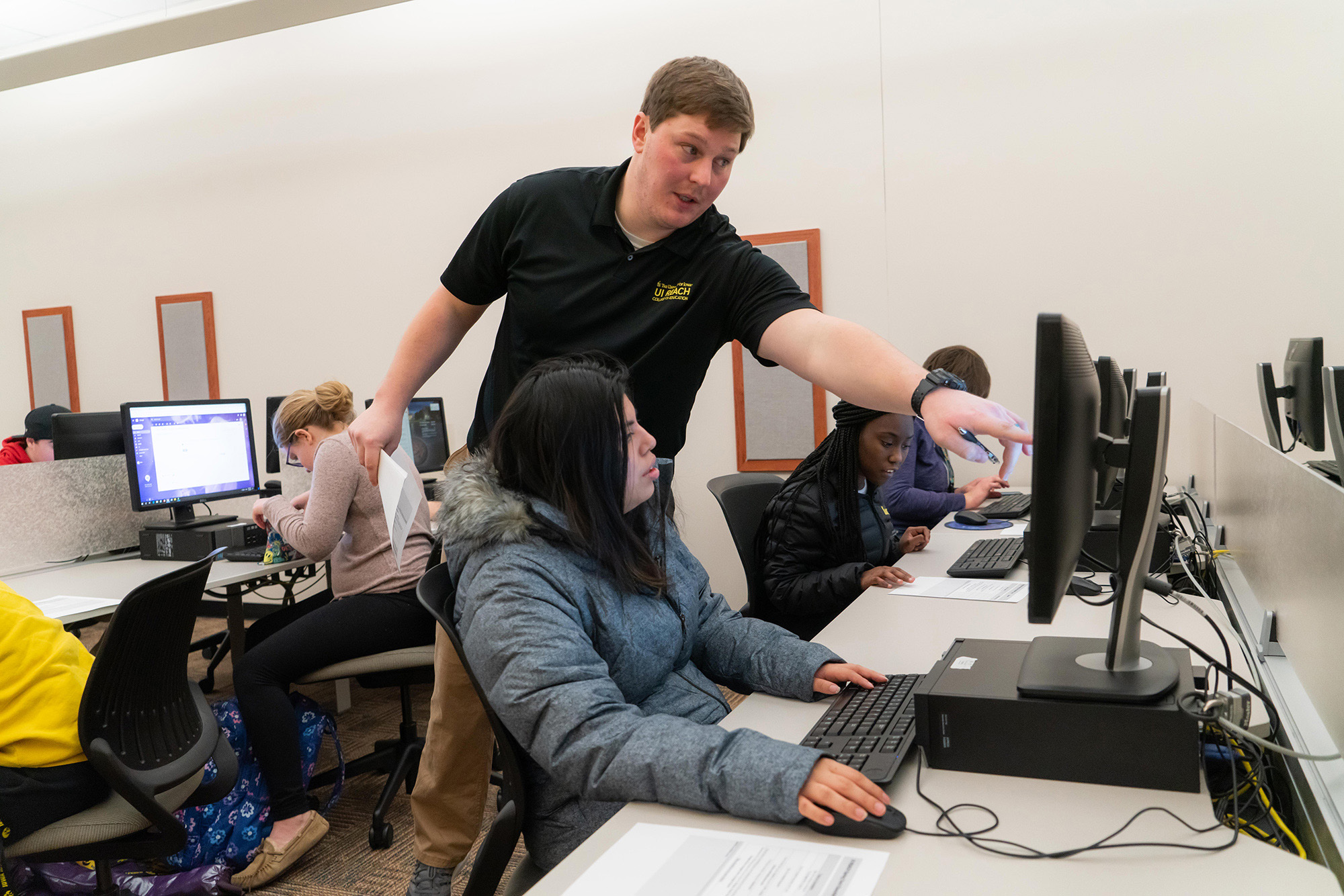 UI reach person helping student in computer lab