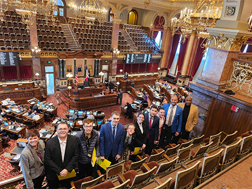 UI REACH students and staff stand in a balcony of the Iowa State Capitol building