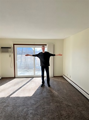 Sam Rame stands in an apartment