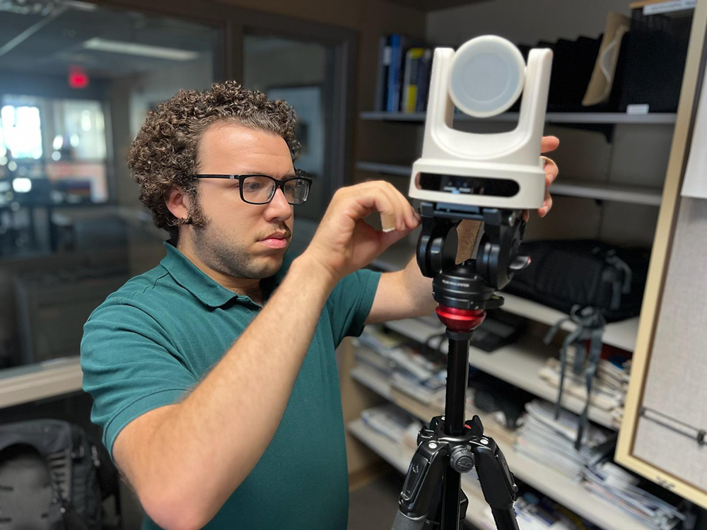 student adjusts filming equipment