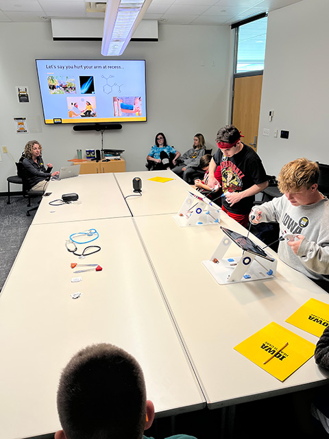 Students sit around a table, trialing medical equipment.