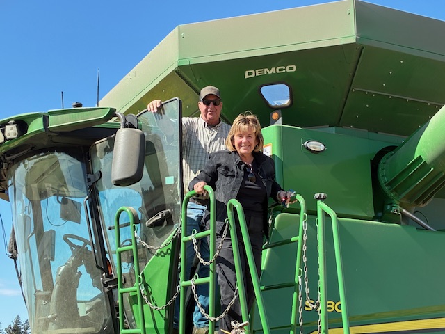 President Wilson stands atop farming equipment.