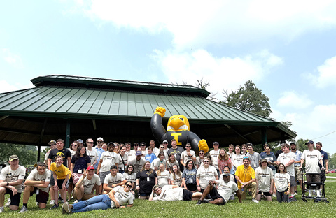 A large group of UI REACH community members gather around an inflatible Herky the Hawk.