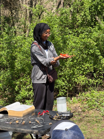 Liberty High School senior Saria Abdalla holds a male Northern Cardinal and smiles