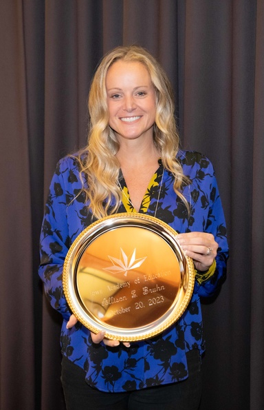 Allison Bruhn holds a plate commemorating her induction to the Iowa Academy of Education.