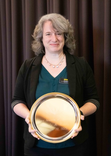 Pat Wesley holds a plate commemorating her induction to the Iowa Academy of Education.