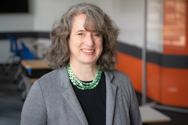 Professional woman smiles in a university classroom.