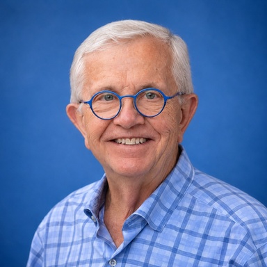 Thomas Schnack portrait wearing glasses and a plaid blue shirt