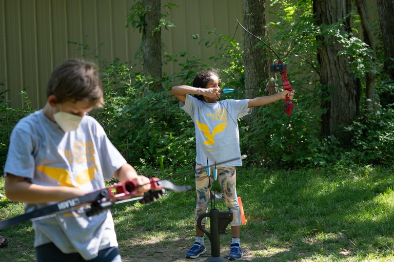 youth campers learning to shoot a bow and arrow 