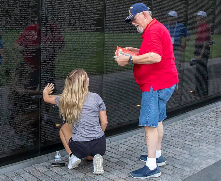 Weber talks with a veteran in front of a war memorial in Washington, D.C.