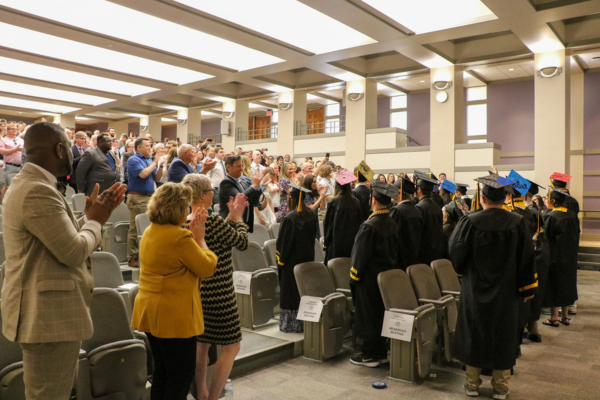 Audience applauds graduates.