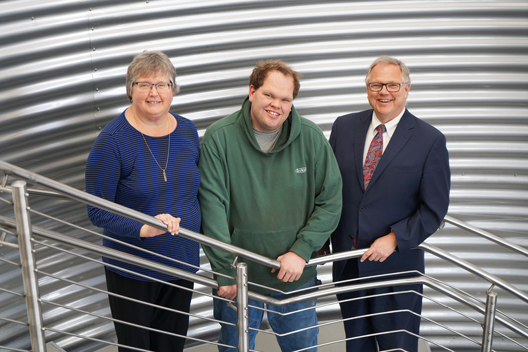 Mary and Charles Sukup with their son, Andrew, at their business in front of a grain bin.