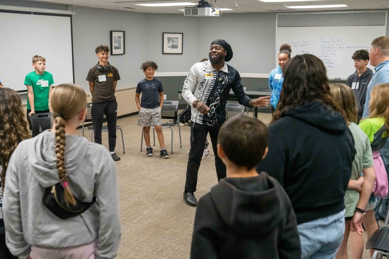 students stand in circle around a presenter