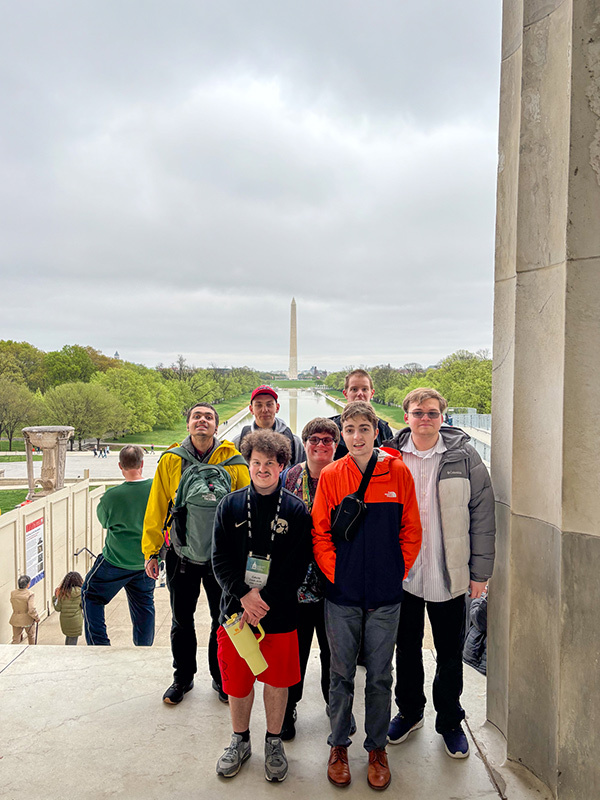 A group of students stand in front of the Washington Monument.