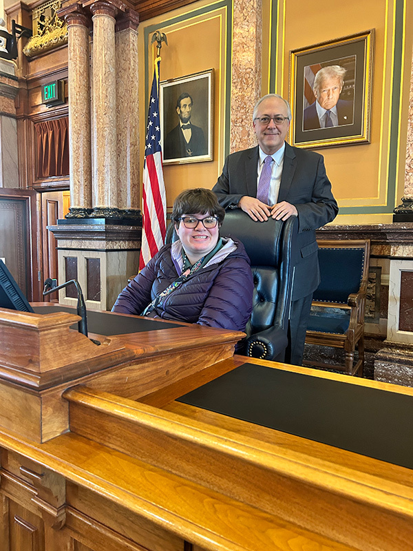 Annie Garcia sits in a chair in front of Dave Young.