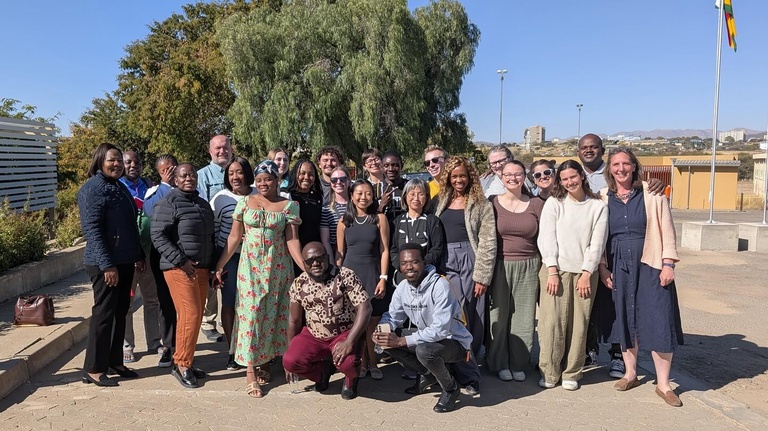 Group of people pose for photo outside