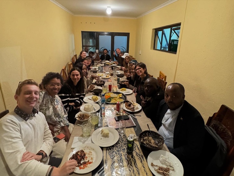 Group of people sit at table, sharing meal