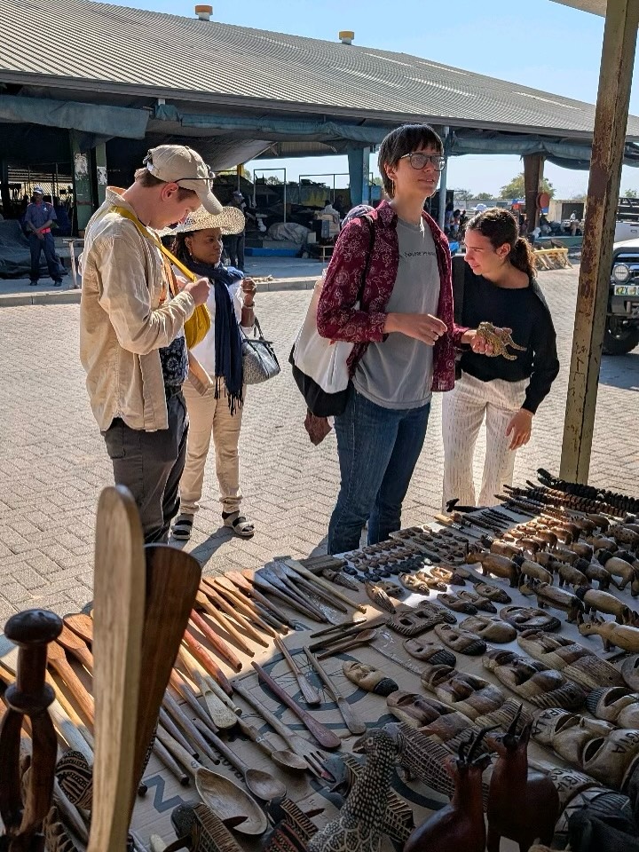 Group of four people stand at street vendor in Namibia