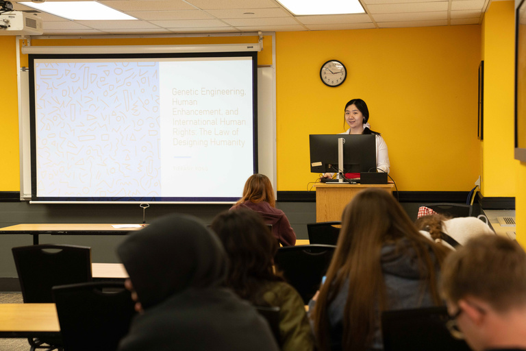 Woman presents in front of students in a classroom