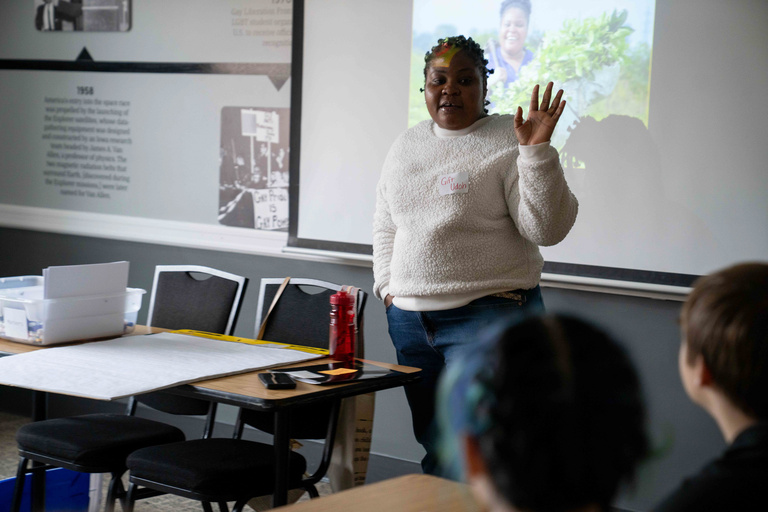 Woman stands at front of classroom