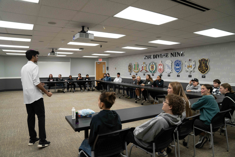 Man stands in front of classroom of kids
