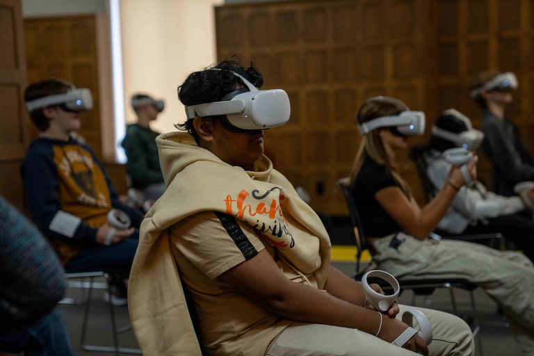 Students sit with virtual reality goggles on