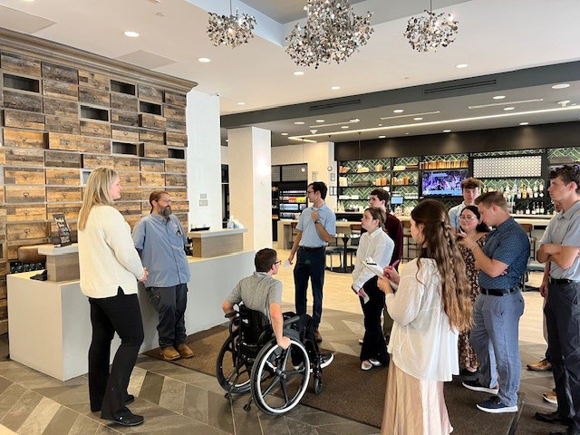 Students stand together in a hotel lobby.