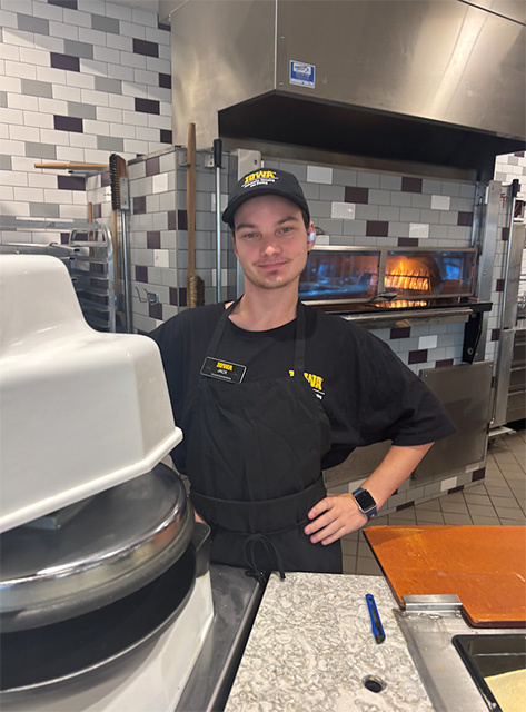 : Jack stands in the dining hall kitchen, wearing his uniform.