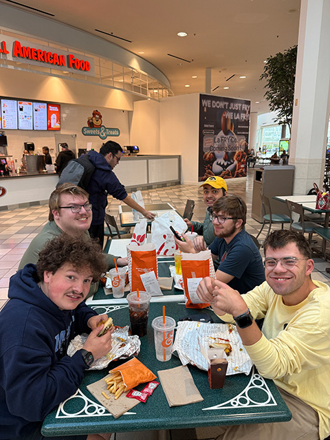 Students eat together at the mall.