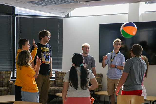 A group of students play with a beach ball.