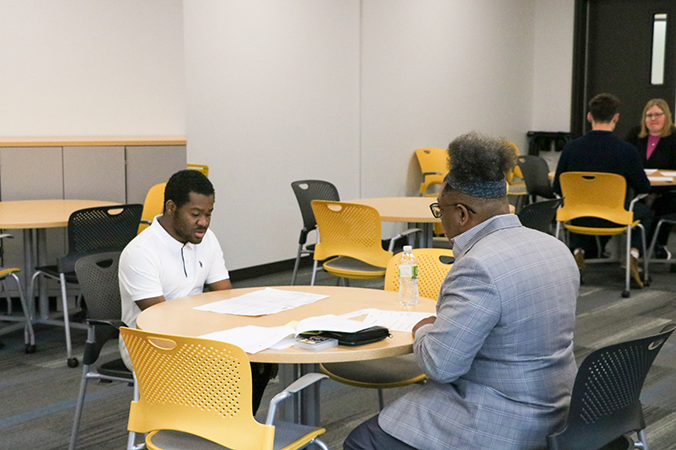 A student speaks to an employer at a mock job interview.