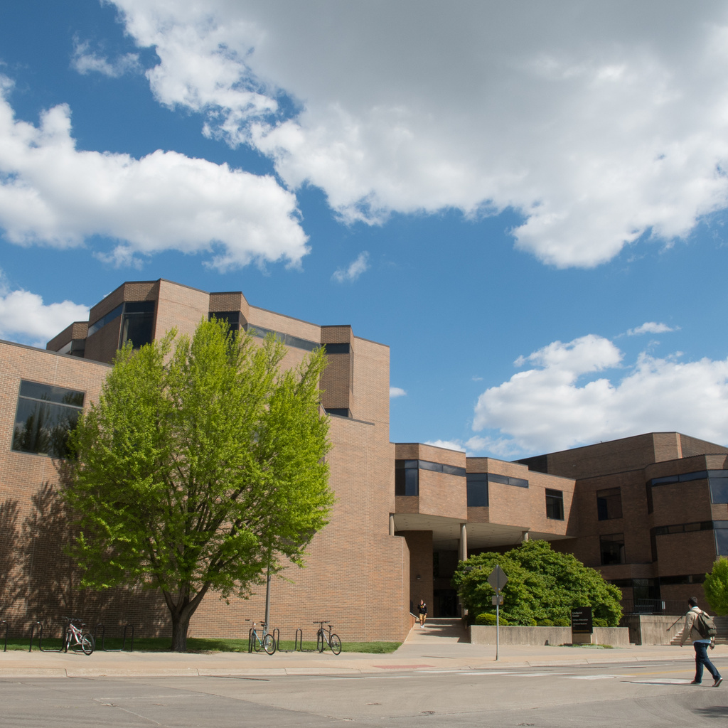 Blue sky dotted with puffy white clouds above the college's Lindquist Center. 