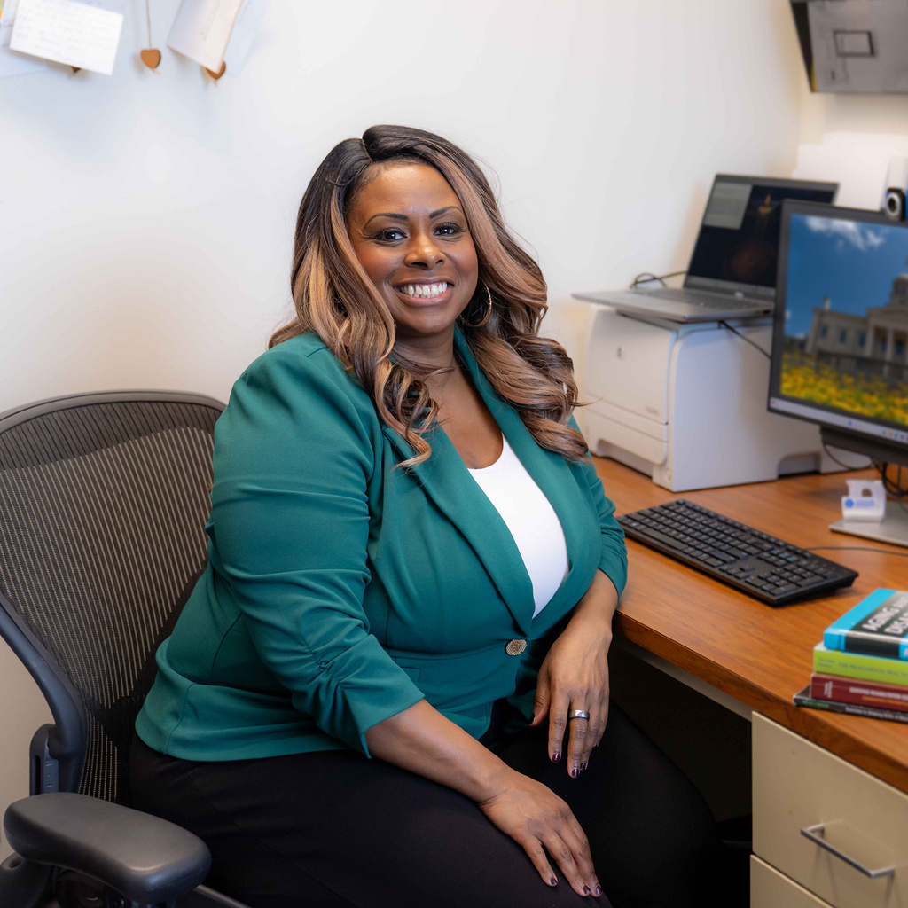 Black woman professor smiles in front of computer