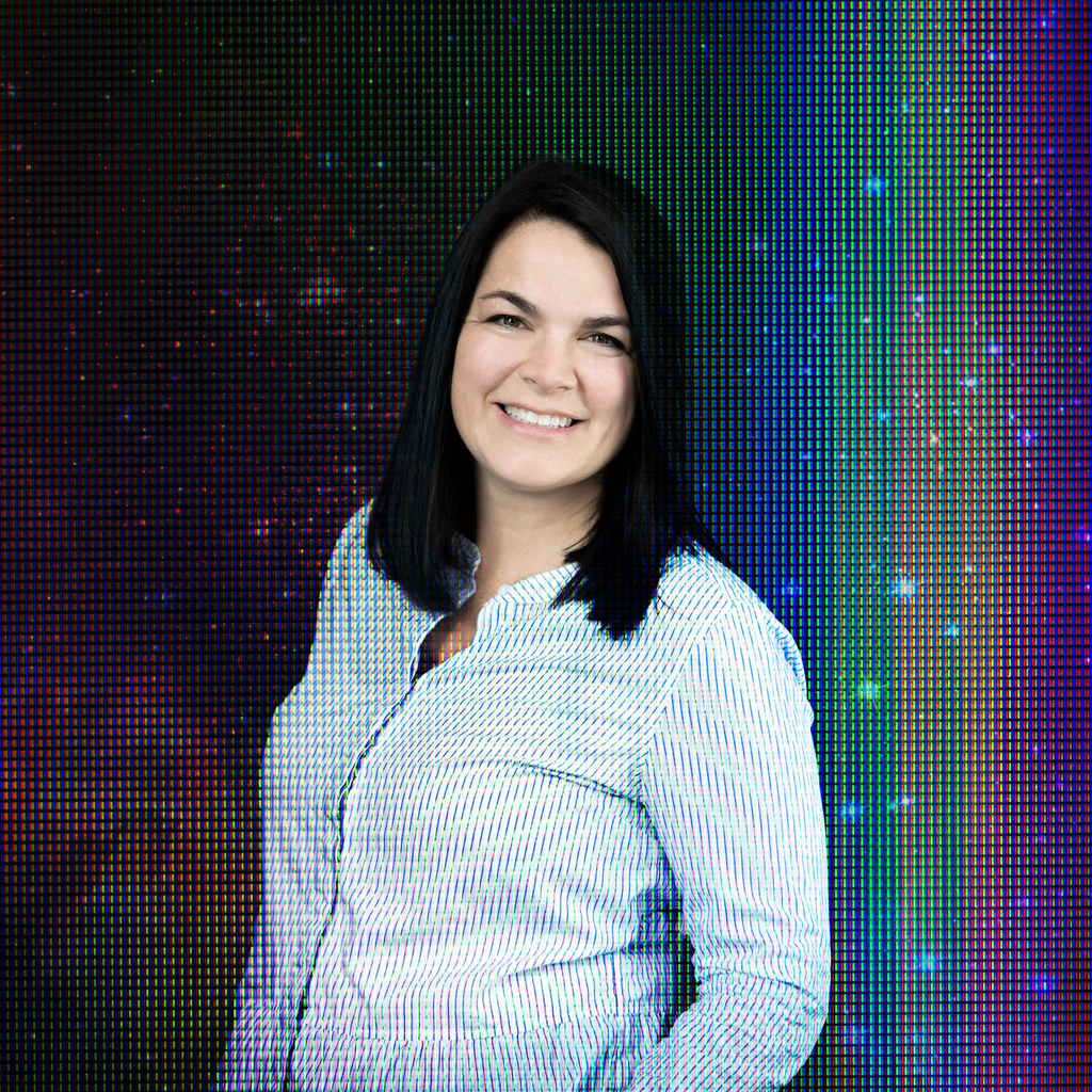 Woman smiles in a field of abstract rainbows
