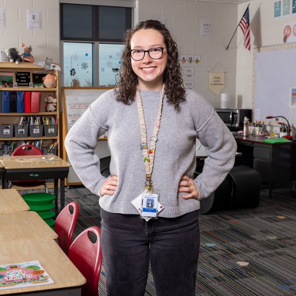 A female teacher stands in her classroom decorated for a new school year.