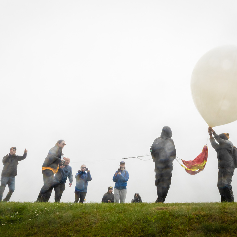 Students and faculty, outside, preparing to launch their balloon