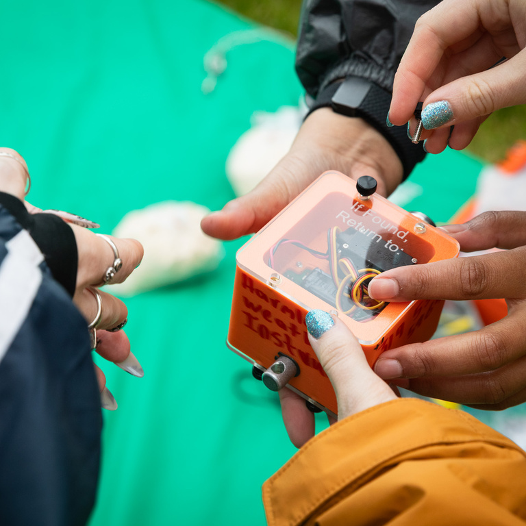 Sets of hands making last minute preparation to the payload prior to launch. 