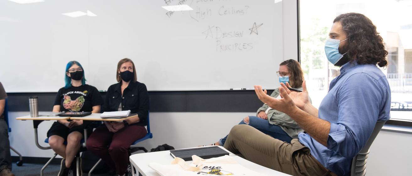 Professor speaking with students classroom