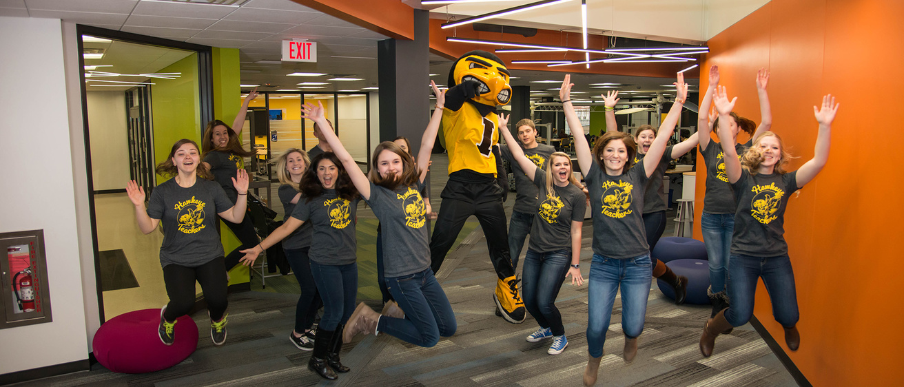 Students jumping with Herky