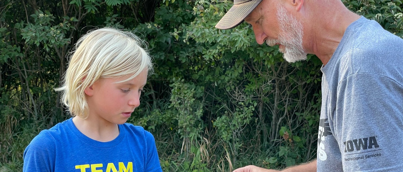 Dave Conrads shows a young student how to tag a bird.