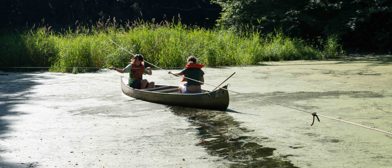 two UI WILD campers exploring in a canoe 