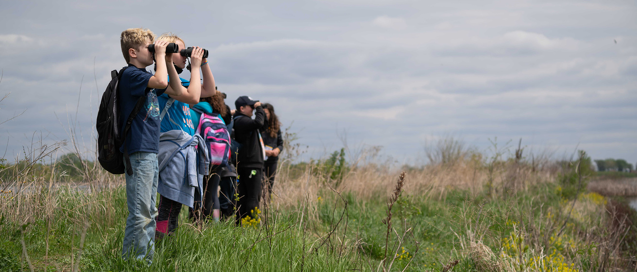 Students exploring the horizon with binoculars during School of the Wild