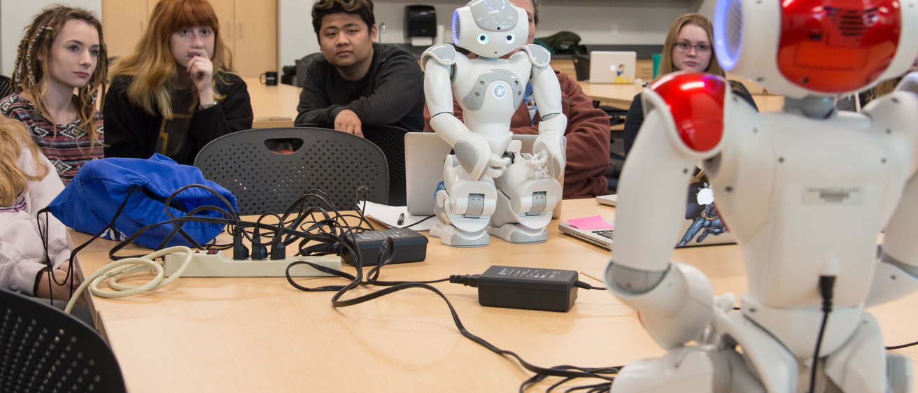 High school students operate robots as part of a STEM learning activity.