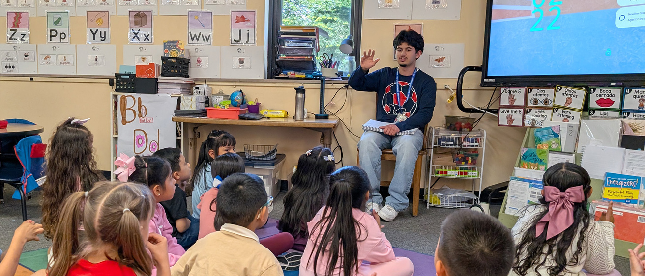 Uriel reads to a classroom of elementary school children