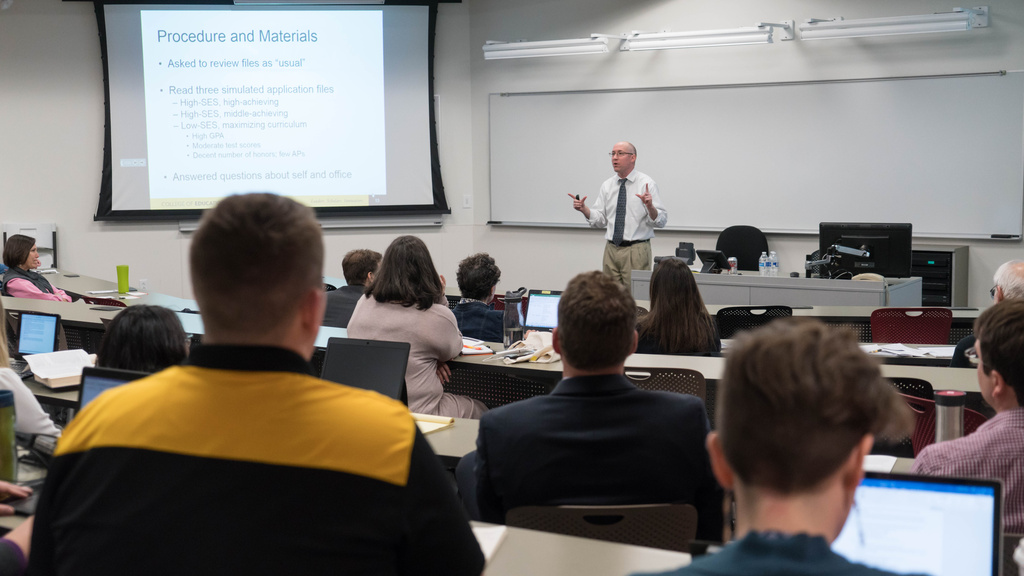 Professor lecturing to group in large classroom