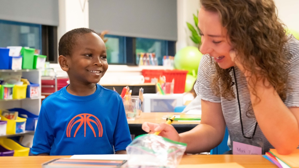 Student teacher writing with elementary student.