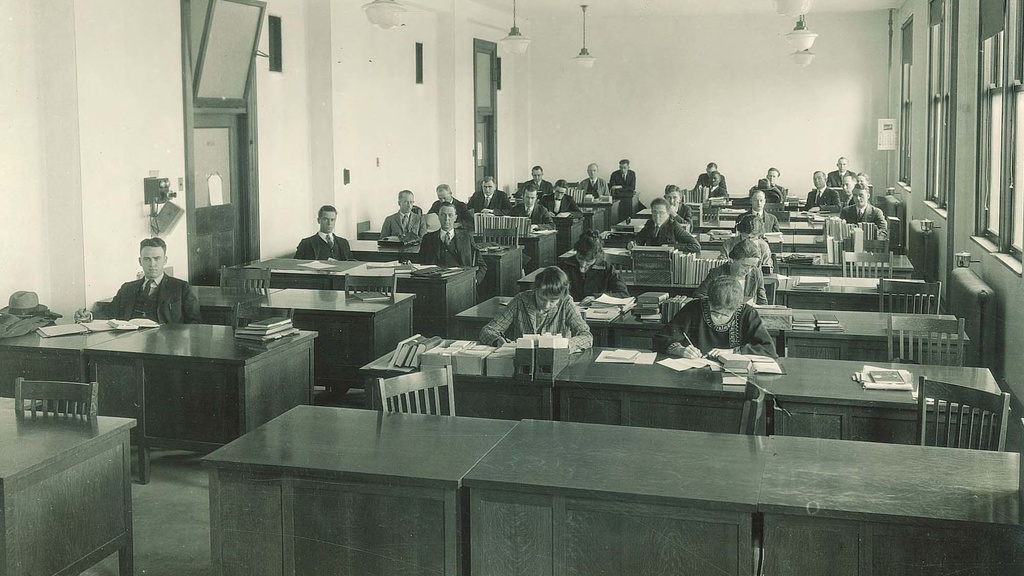 Antique photo of large office filled with desks