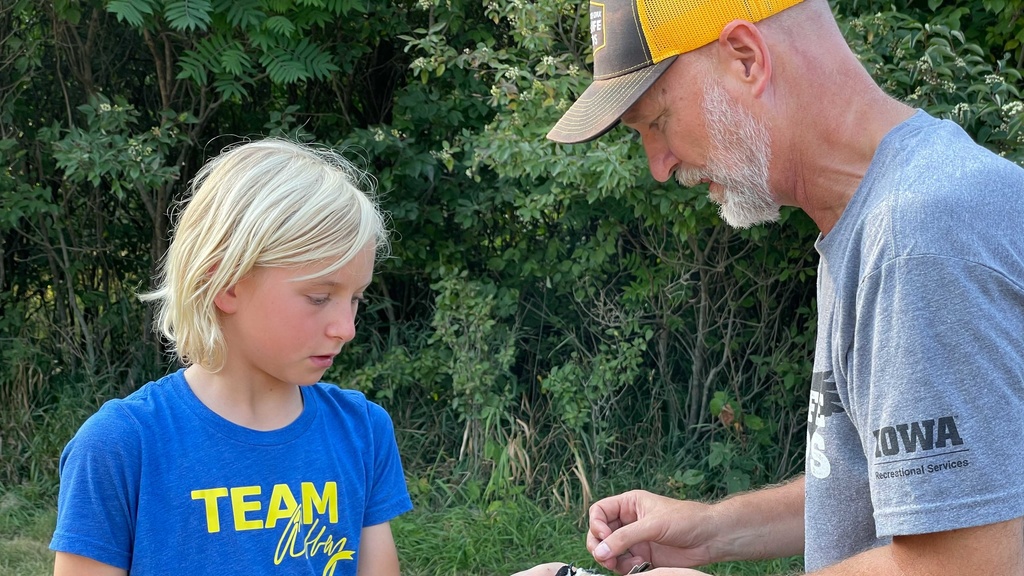 Dave Conrads shows a young student how to tag a bird.