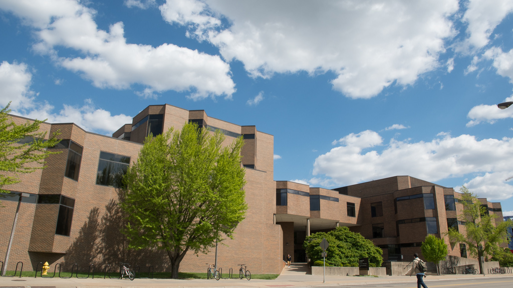 Blue sky dotted with puffy white clouds above the college's Lindquist Center. 