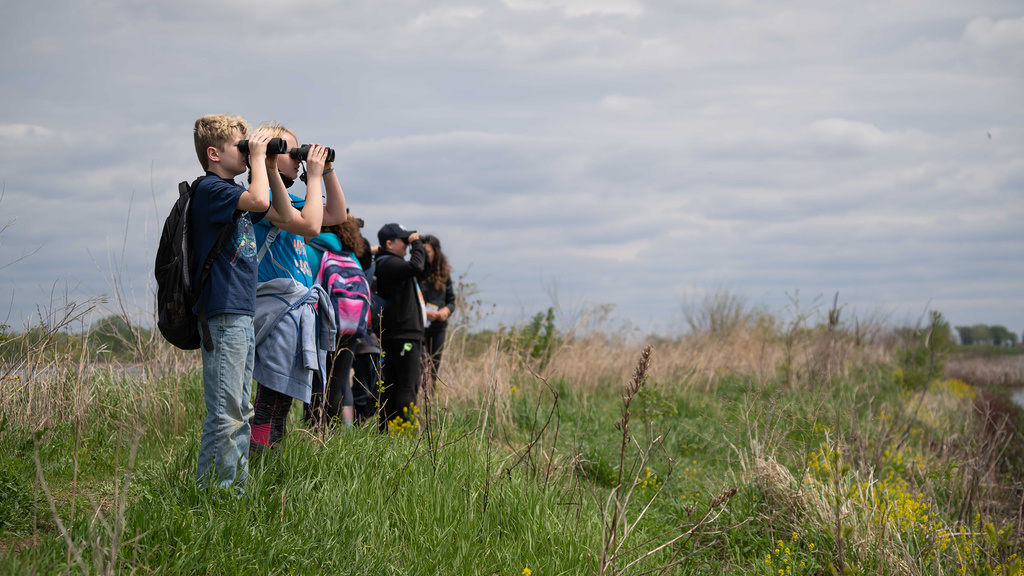 Students exploring the horizon with binoculars during School of the Wild